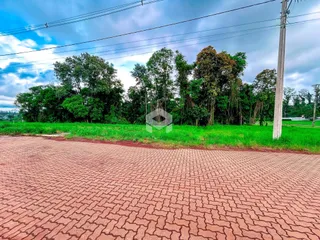 Vista externa da propriedade com gramado e área pavimentada.