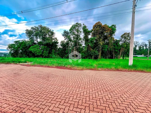 Vista externa da propriedade com gramado e área pavimentada.