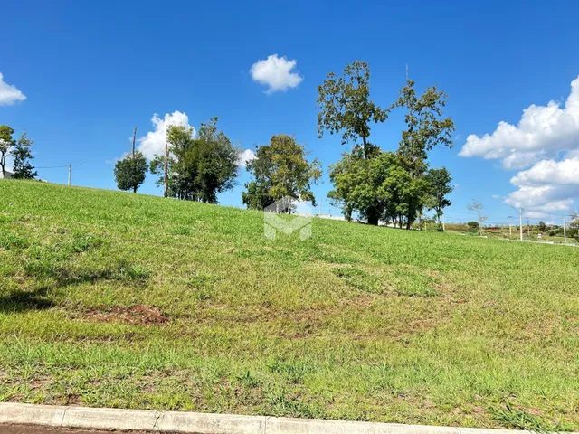 Paisagem de um campo gramado verde sob um céu azul claro.