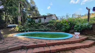 Piscina externa com borda de tijolos vermelhos em uma propriedade em Lajeado.