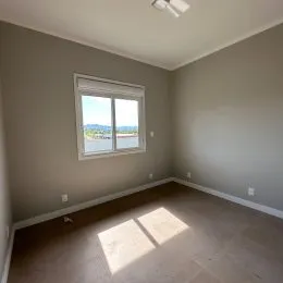 Foto interna de um cômodo com janela mostrando a vista externa.