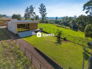 Fachada de uma casa moderna com vista para uma paisagem verde e montanhosa.