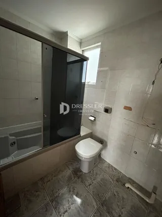 Foto de um banheiro com revestimento cerâmico e louças sanitárias.