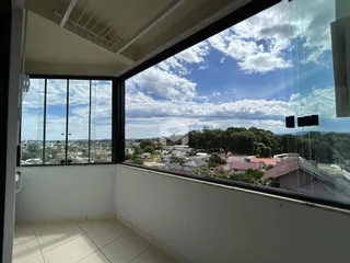 Vista panorâmica da paisagem da cidade e da mata a partir de uma varanda.