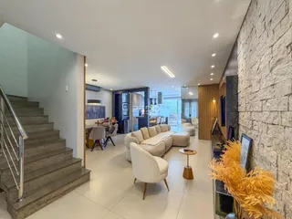 Sala de estar moderna com área de jantar e escadaria em um imóvel em Lajeado.
