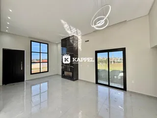 Sala de estar ampla com piso claro e lareira de pedra escura.