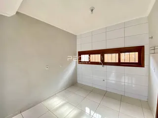 Foto de um ambiente interno com piso de cerâmica branca e parede clara.
