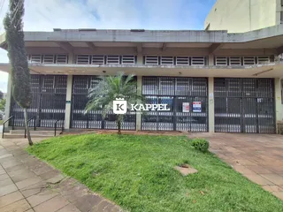 Fachada da residência em Lajeado, Brasil, com portão de metal e área gramada na frente.