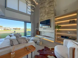 Sala de estar moderna com grande janela e vista para o exterior.