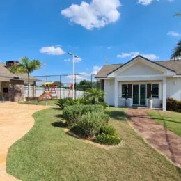 Fachada de uma casa com gramado verde sob um céu azul.