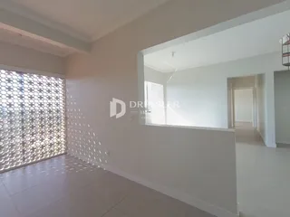 Vista interna de uma sala com parede branca e piso claro.