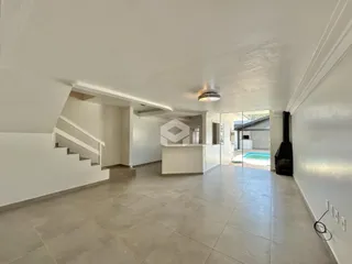 Vista interna de uma área ampla com piso de cerâmica e escadaria.