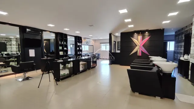 Ambiente interno com móveis escuros e iluminação clara em um espaço comercial.
