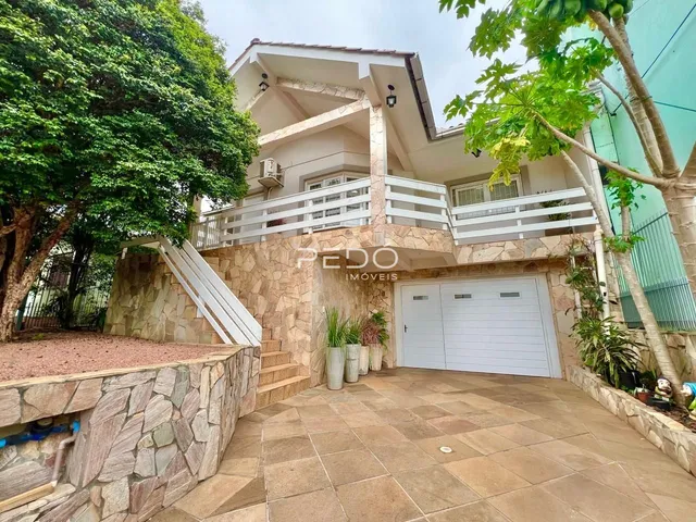 Fachada de uma residência em Lajeado, Brasil, com revestimento de pedra e área externa.