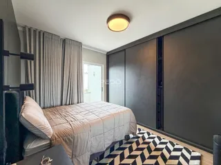 Quarto com cama e cortinas em um imóvel moderno.