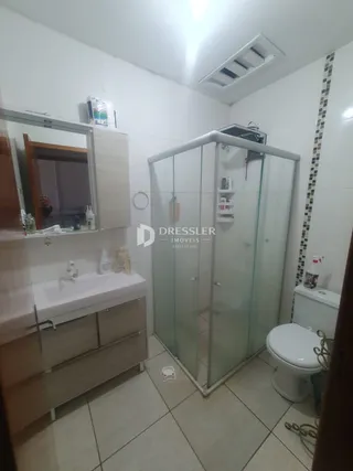 Foto de um banheiro com box de vidro e vaso sanitário.