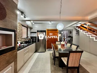 Ambiente de cozinha e jantar com armários modernos e iluminação clara.