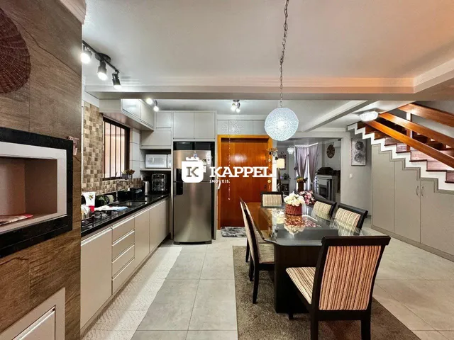 Ambiente de cozinha e jantar com armários modernos e iluminação clara.