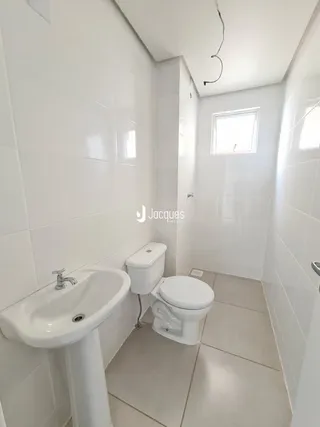 Foto de um banheiro interno com piso de cerâmica e paredes brancas.