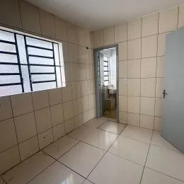 Vista interna de um corredor com piso e paredes de azulejo claro.