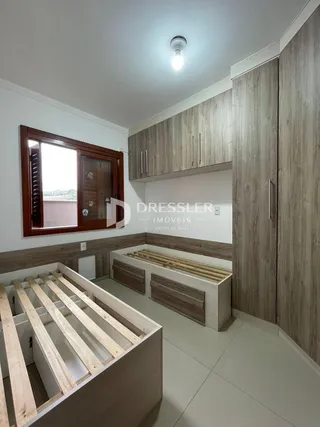 Quarto com cabeceira de madeira e armários em um ambiente moderno.