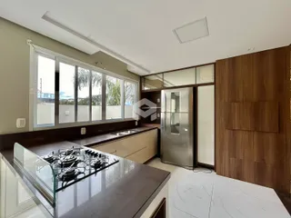 Vista da cozinha moderna com bancada e janela de grande porte.