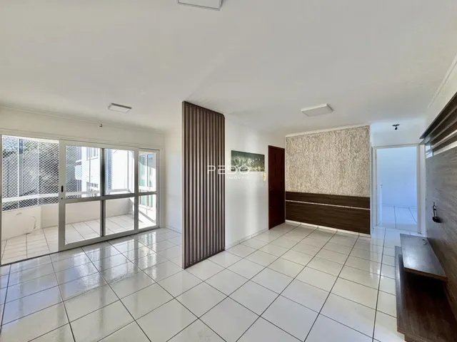 Sala de estar com piso de cerâmica e portas de vidro que dão acesso ao exterior.