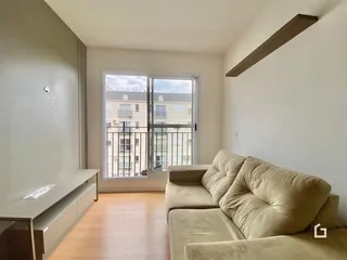 Sala de estar com piso de madeira e vista para o exterior.
