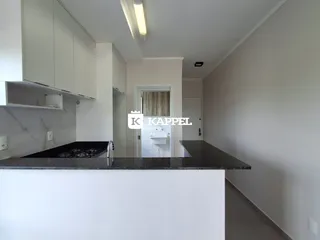 Foto de uma cozinha moderna com armários brancos e bancada escura.