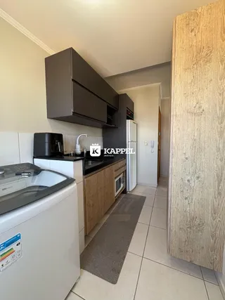 Cozinha com armários escuros e bancada de trabalho.
