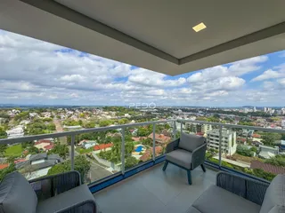 Vista panorâmica da cidade de Lajeado a partir de uma varanda com móveis.