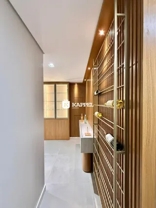 Um corredor interno com painéis de madeira e uma estante vertical.