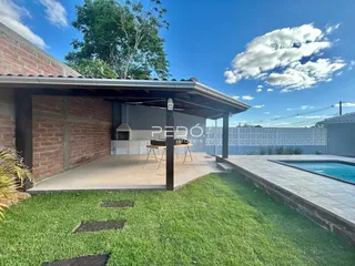 Fachada de casa com área externa e piscina.