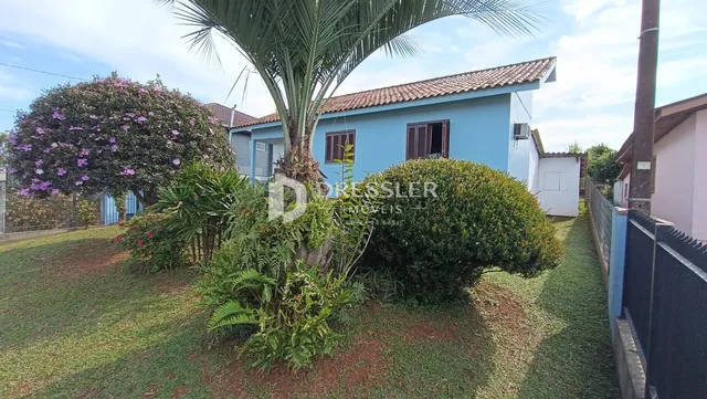 Fachada de uma casa em Lajeado, Brasil, com jardim e vegetação exuberante.