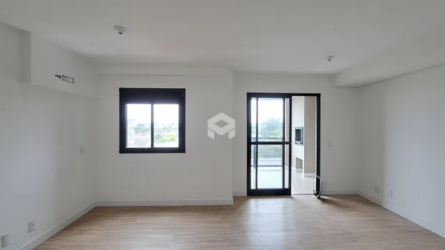 Sala de estar com piso de madeira clara e paredes brancas.