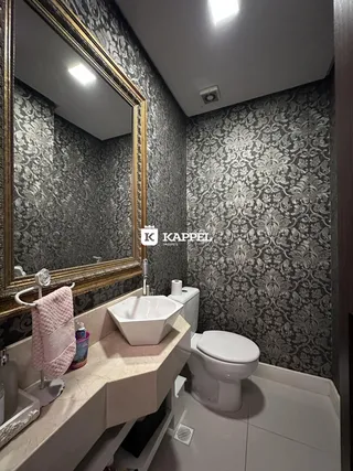 Banheiro com revestimento de parede estampado e bancada de mármore branca.