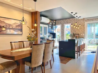 Vista de uma sala de jantar com mesa de madeira e cadeiras em um imóvel no Brasil.