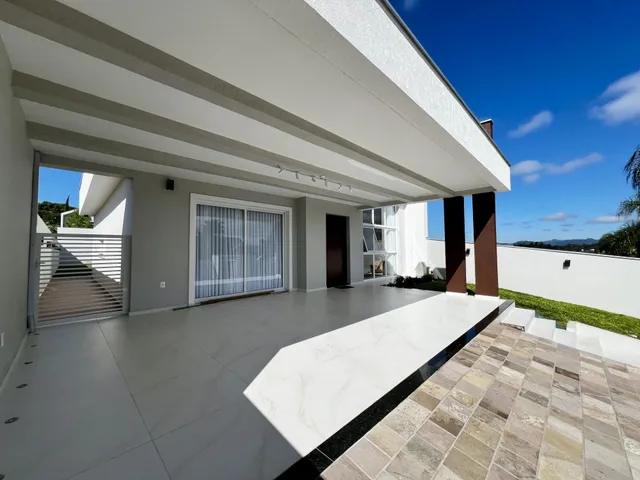 Fachada moderna de uma residência em Lajeado, Brasil, com área externa pavimentada.