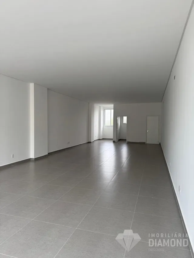 Hall de corredor com paredes brancas e piso de cerâmica.
