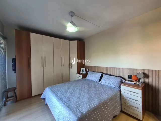Quarto com armários em madeira e cama no interior de uma residência.