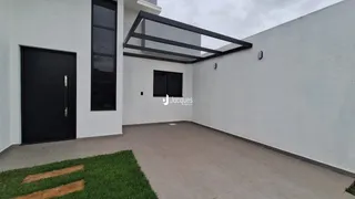 Fachada moderna de uma residência branca com porta escura e estrutura de telhado exposta.