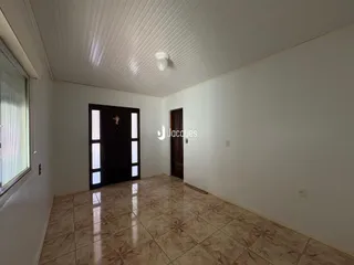 Interior de um ambiente com piso de cerâmica e porta escura.