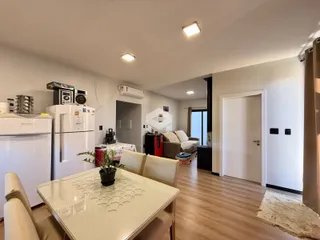 Ambiente interno de uma sala de estar com cozinha aberta em Lajeado.