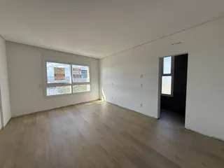 Sala de estar com piso de madeira clara e janela.