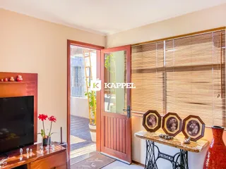 Sala de estar com porta de madeira e acesso a uma área externa.