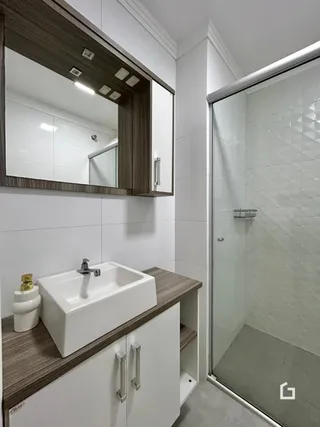 Foto de um banheiro moderno com box de vidro e bancada de madeira.