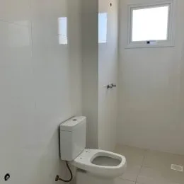 Vaso sanitário branco em um ambiente interno.