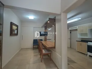 Hall de entrada com piso de cerâmica claro e paredes brancas.