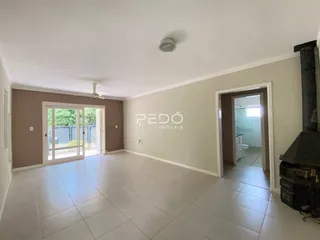 Sala de estar com piso de cerâmica e porta de vidro abrindo para o exterior.