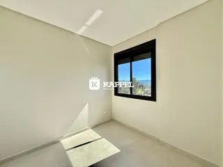 Vista interna de um cômodo com paredes brancas e piso claro.